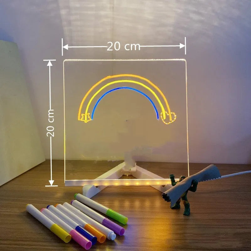 DIY acrylic message board LED night light on desk with colourful writing, USB cable, and pens