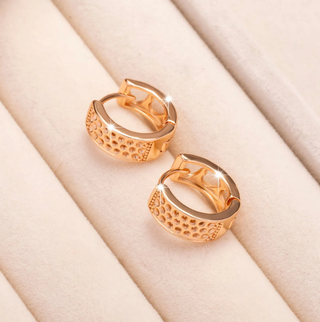 A pair of rose gold hollowed-out heart earrings on a white background, showing three-dimensional openwork detail.