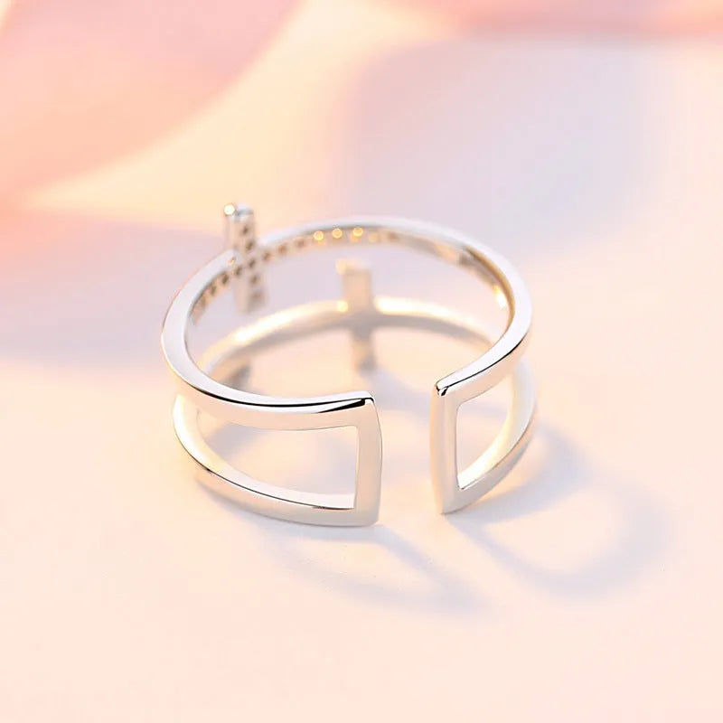 Adjustable open copper ring with a miniature double cross design inlaid with zircon stones.