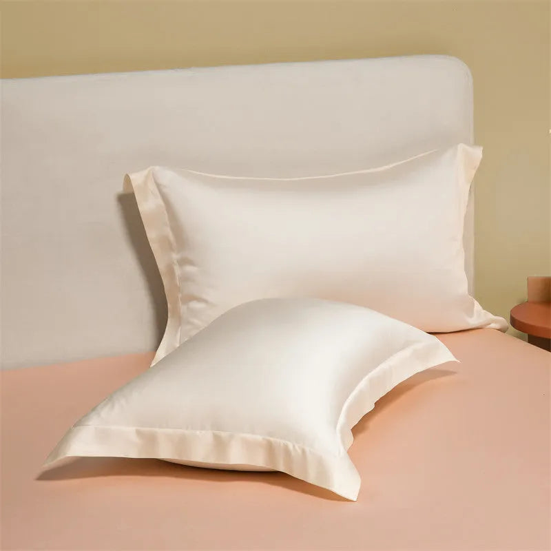 A modern, neatly made bed with a Lenzing Tencel duvet cover and pillowcases in a choice of nine colours like Sea Salt Blue.