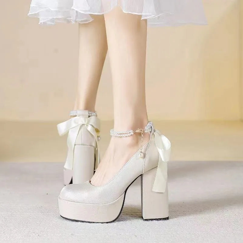 Women's creamy white waterproof wedding pumps with a thick platform heel and buckle detail.