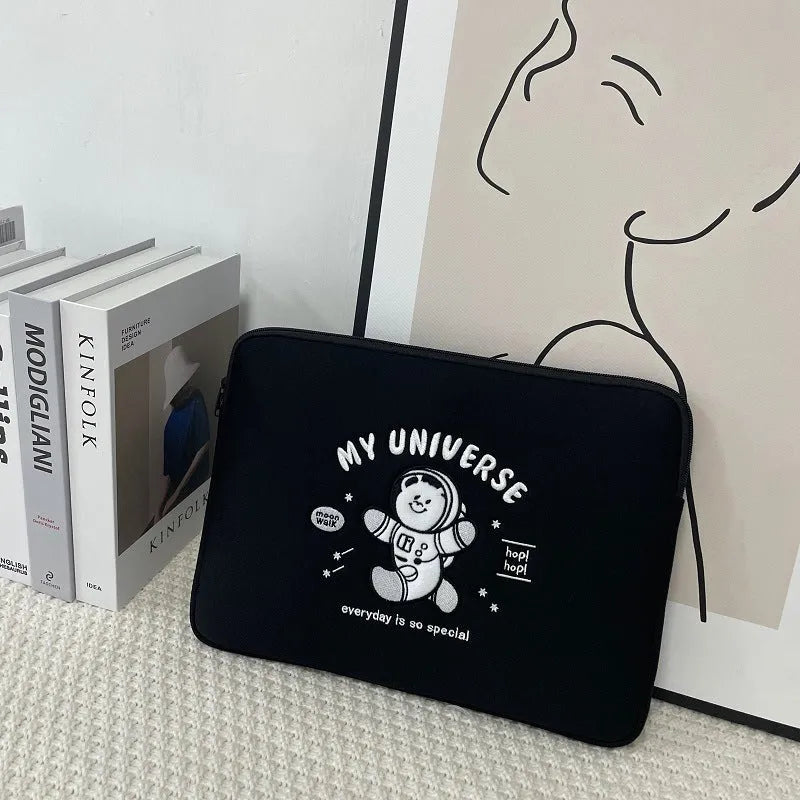 Embroidered animal design laptop sleeve in polyester, shown next to a laptop.
