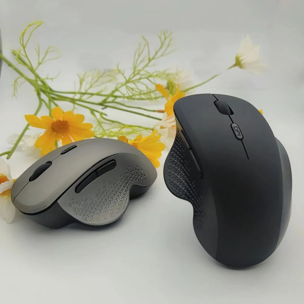 Grey wireless optical mouse for laptops with USB charging cable on white background