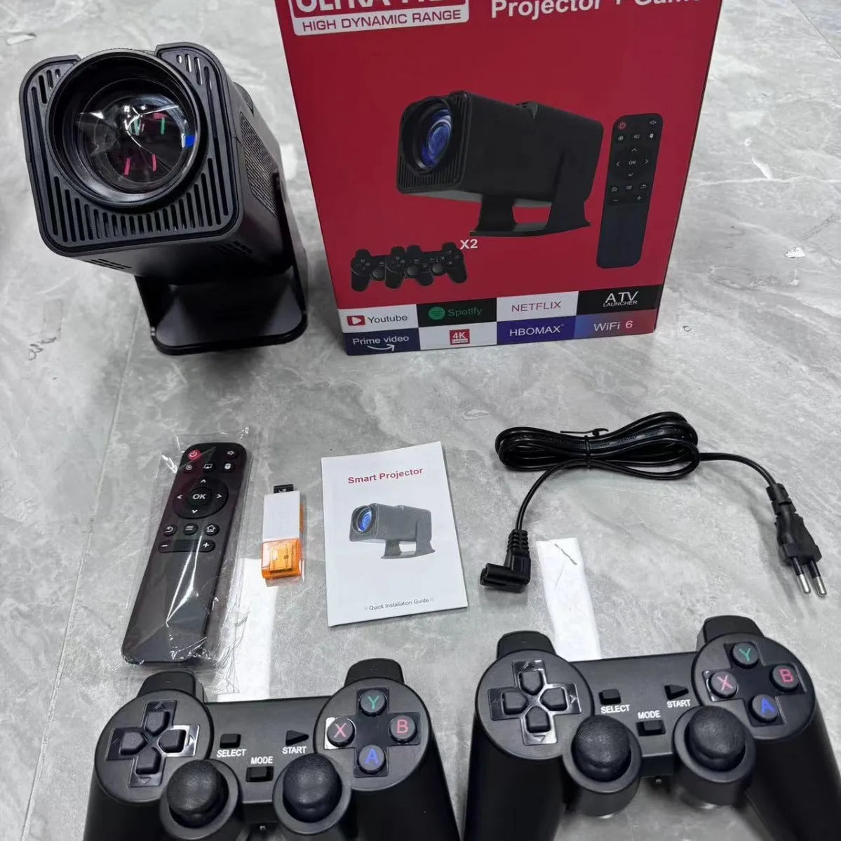 A wireless home projector with a handheld remote on a table, set up for big-screen gaming or movie viewing.