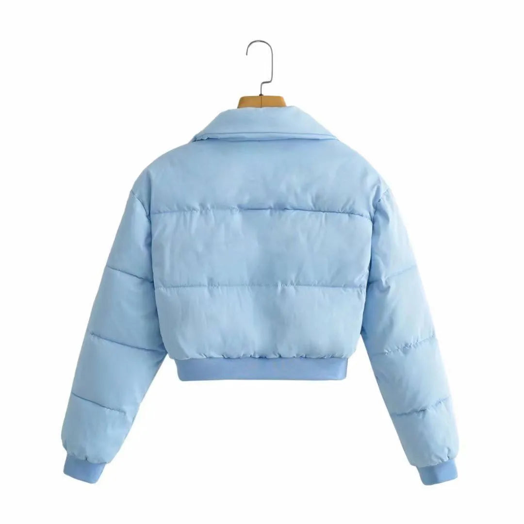 A woman's loose-fitting blue polyester casual jacket with long sleeves on a hanger.