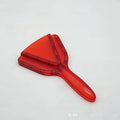Red adjustable telescopic can and bottle opener with non-slip handle on a kitchen counter.