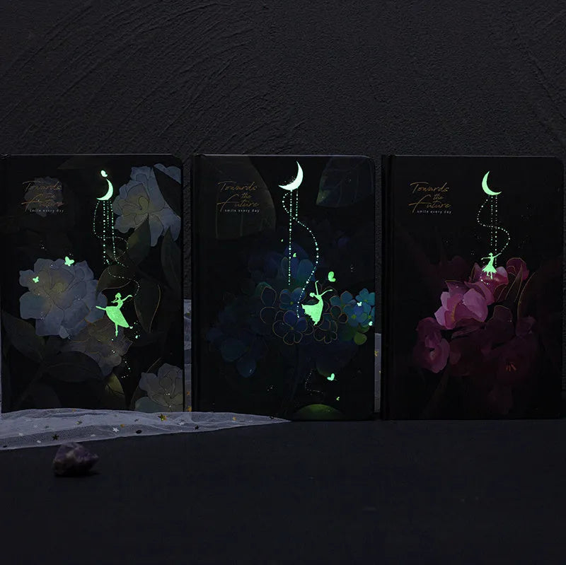 A5 notebook with luminous cover showing colour options: deep blue, gold, light blue, purple with internal colour illustrations
