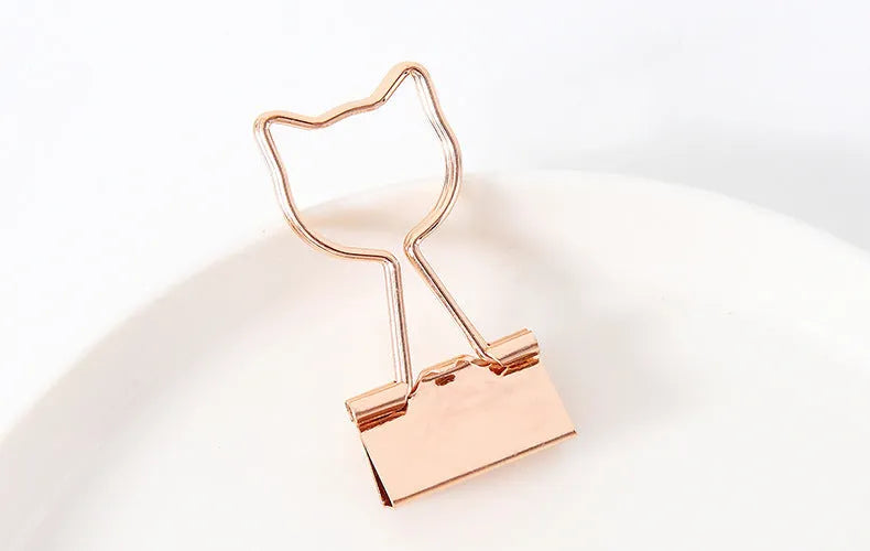 Gold metal paper clip with decorative shape options including bow, cactus, cat, flamingo, love, and clouds.