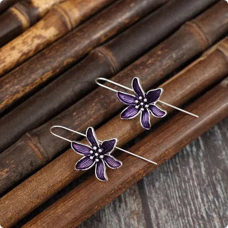Close-up of a pair of purple alloy flower-shaped earrings with a retro elegant style.