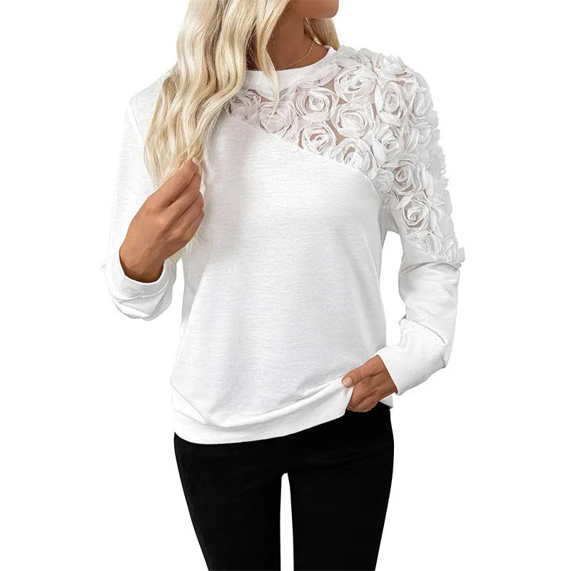White women's long sleeve top with floral pattern, loose fit, on a hanger.
