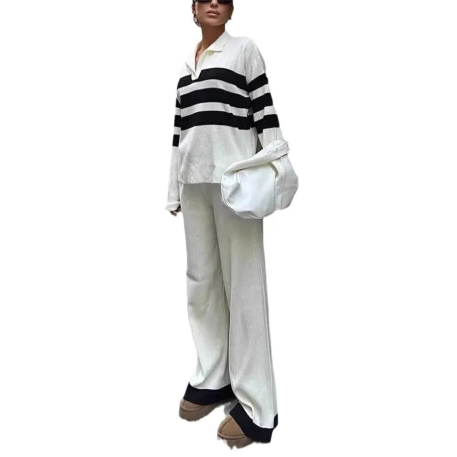 Women's black and white striped knitted two-piece set with polo collar top and full-length trousers.