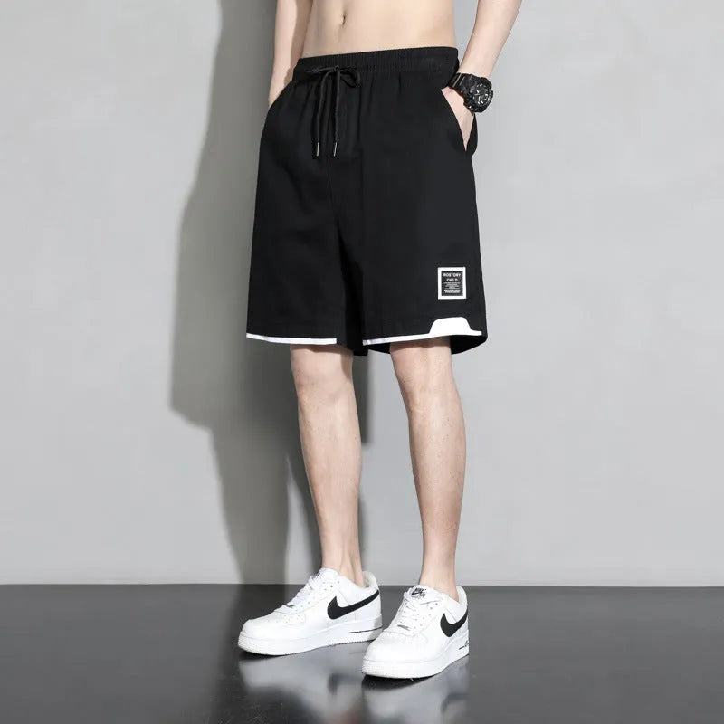 Boys' loose-fitting cotton summer shorts in black, shown on a hanger.