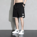 Boys' loose-fitting cotton summer shorts in black, shown on a hanger.