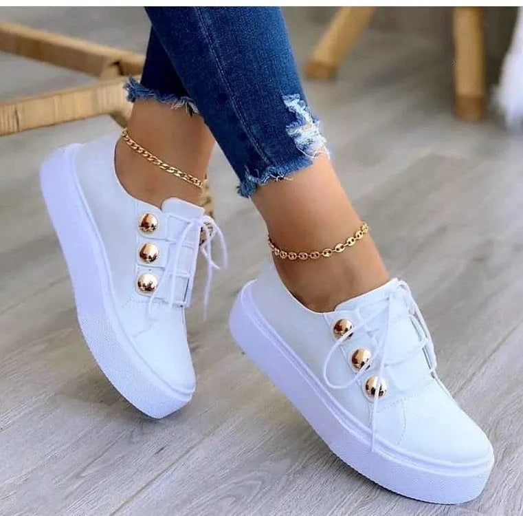 Women's white lace-up casual flats with decorative silver rivets and a round toe.