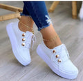 Women's white lace-up casual flats with decorative silver rivets and a round toe.