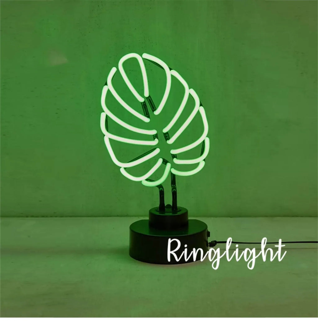 Minimalist white bamboo-shaped desk lamp emitting a soft green glow from its tube.