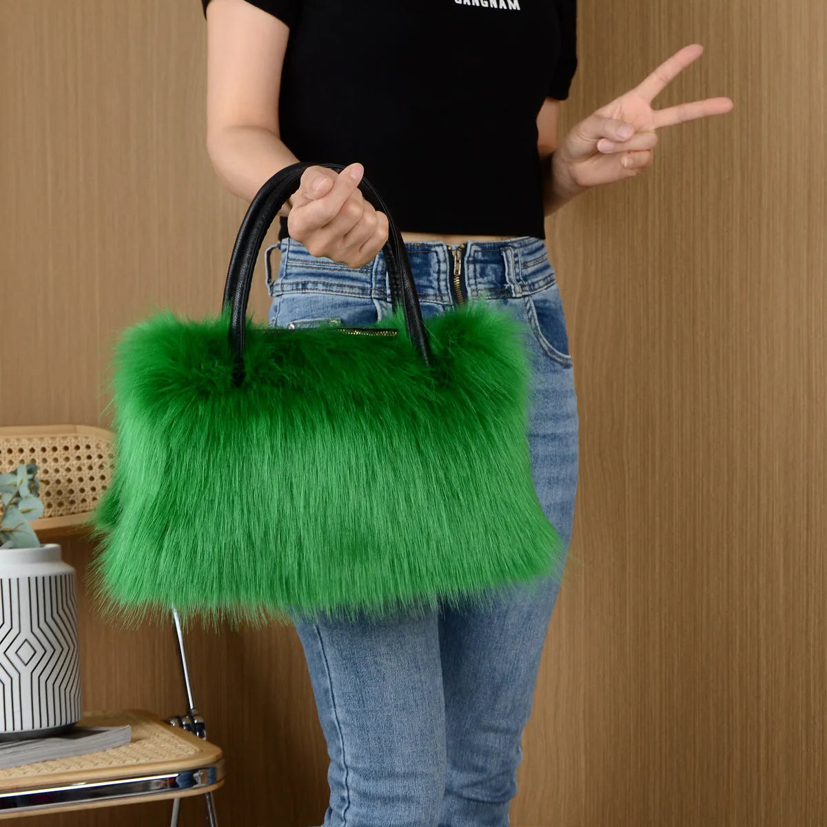 Hand-carrying square plush bag in pink with soft faux fur exterior and horizontal shape