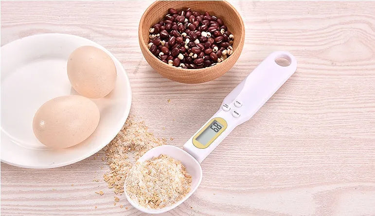 Black electronic measuring spoon scale with digital display showing weight measurement