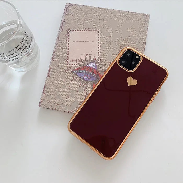 Solid colour TPU back cover case for iPhone on a table, shown in blue, claret, pink, and green.