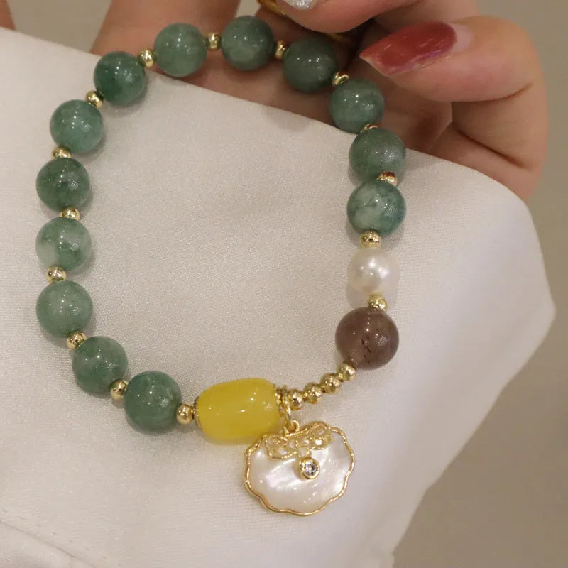 Women's green jade shell bead bracelet showing natural gemstone colour tones