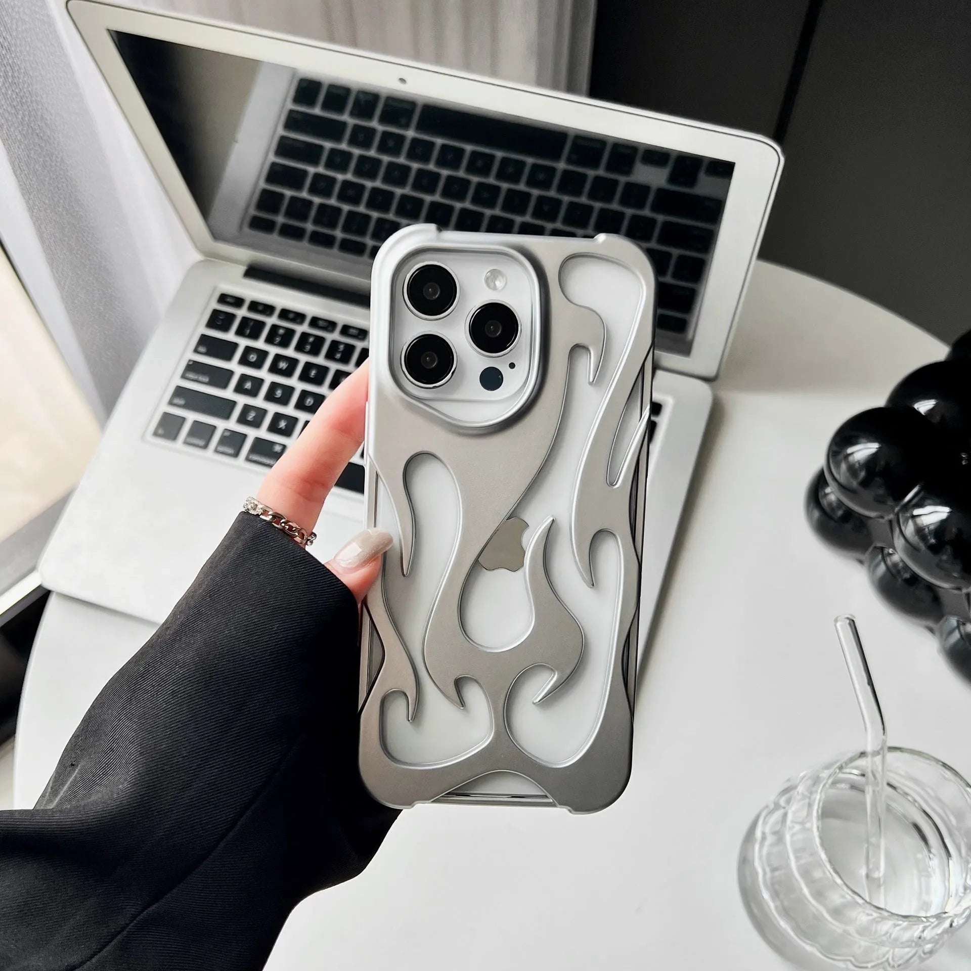 Electroplated hollow flame pattern phone case for iPhone, showing silver finish and perforated design for heat dissipation.