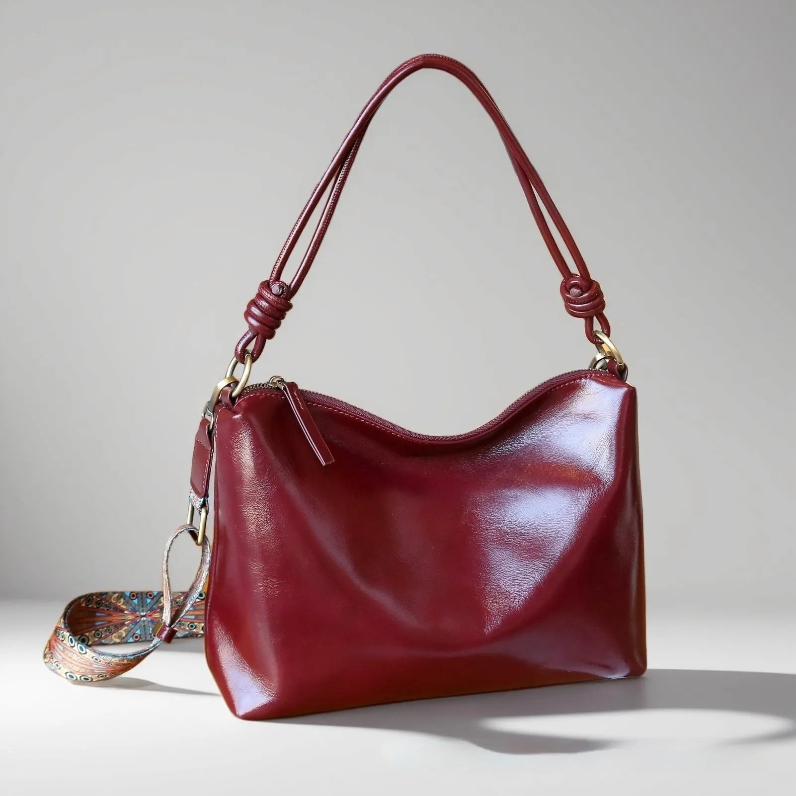 Genuine leather pillow-shaped commuter bag in caramel colour with double straps and patchwork detailing, 31x11x24cm