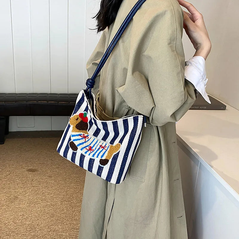 Cartoon sausage dog bucket bag in polyester with canvas lining, soft crossbody shape and single strap.
