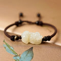 Traditional Chinese Hetian jade bracelet with black and red braided ropes, jade bead centre
