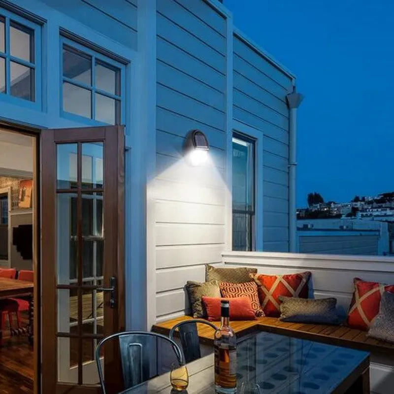Black rectangular solar-powered LED wall light with a solar panel on top.