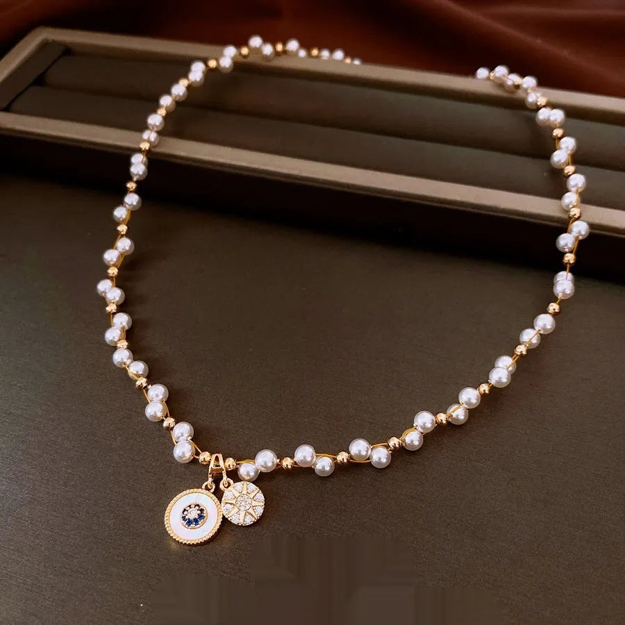 Gold electroplated adjustable clavicle necklace with round zircon and imitation pearl pendant.
