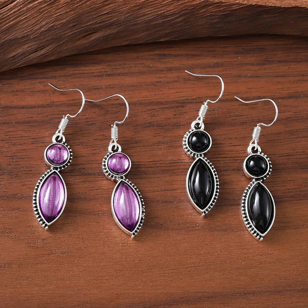 A pair of vintage-style geometric drop earrings with black and purple electroplated pendants on a white background.