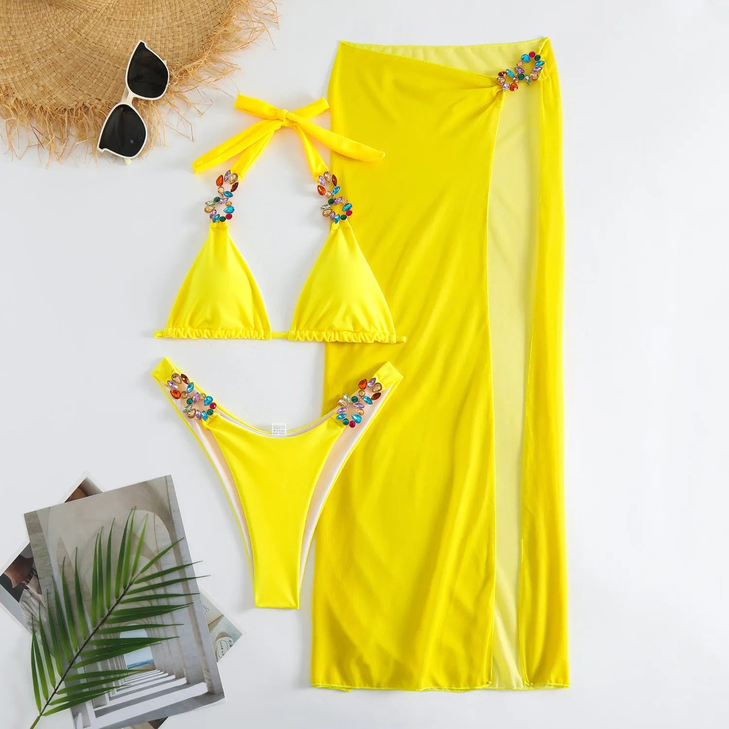 Rose red three-piece swimsuit bikini set with a long mesh skirt laid flat.