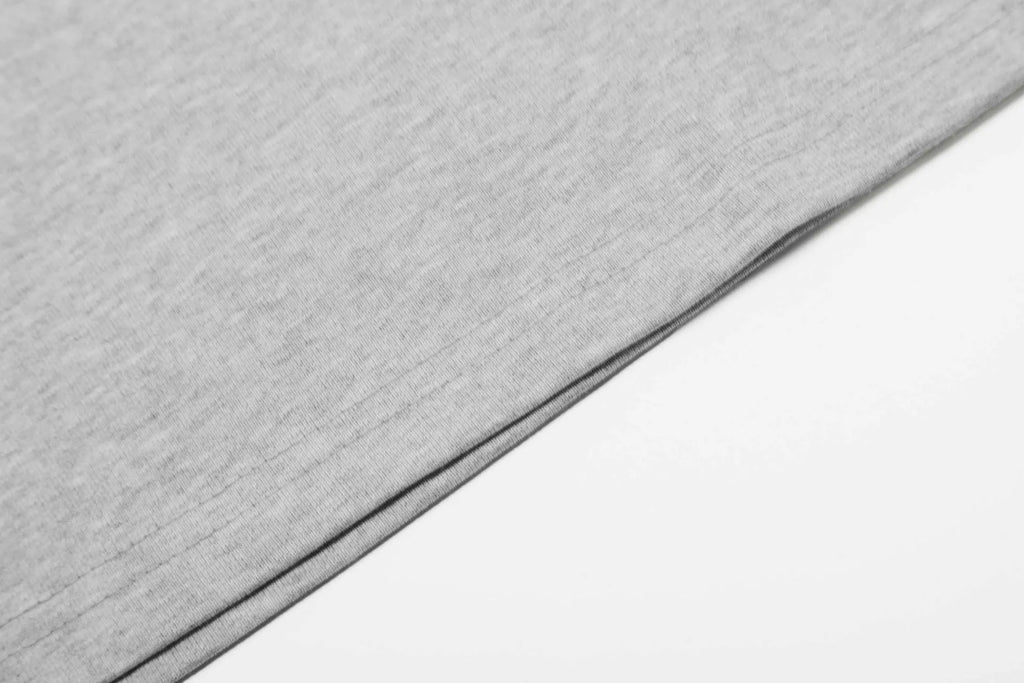 A man or woman wearing a loose grey cotton long sleeve retro pullover.