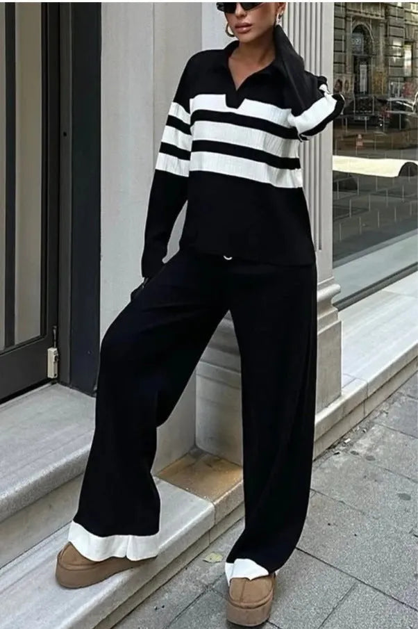 Women's black and white striped knitted two-piece set with polo collar top and full-length trousers.