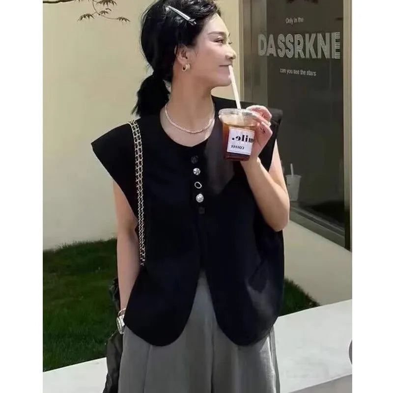 Women's loose fit sleeveless vest in beige and black, showing V-neck and pocket detail.