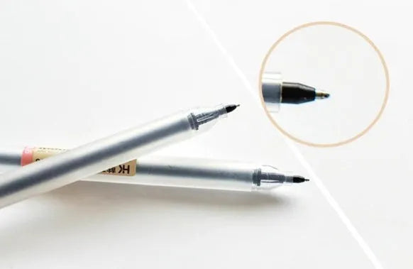 Set of twelve black Muji gel pens with 0.5mm fine nibs, showing anti-leak mechanism and aqueous ink.