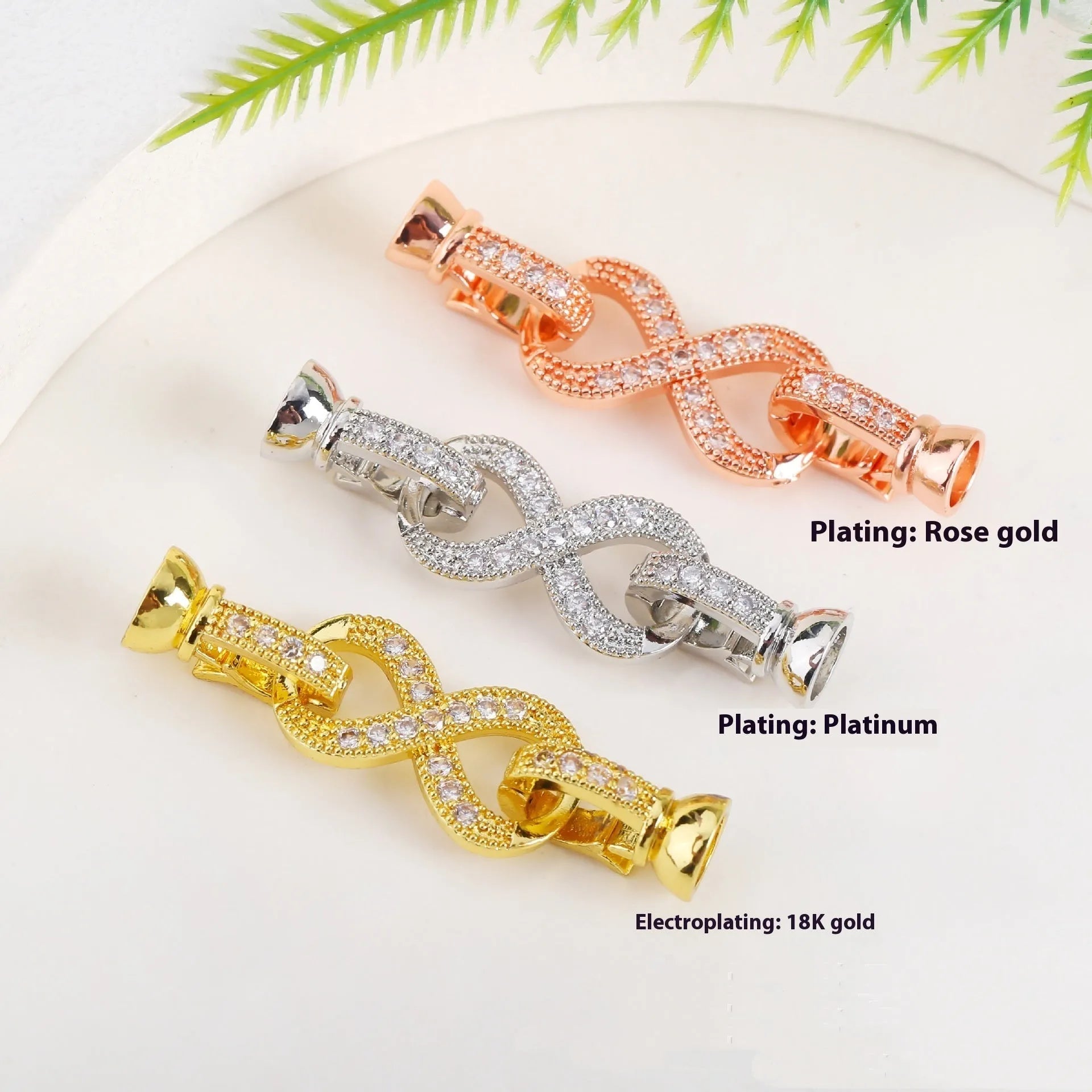 Small gold-colour electroplated metal jewellery buckle clasp on a white background.