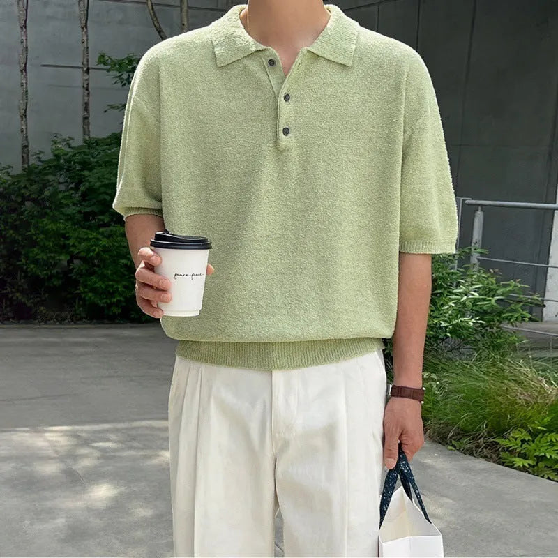 A caramel coloured men's loose-fit knitted polo shirt with short sleeves on a hanger.