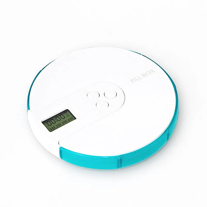Blue seven-compartment electronic pill box with digital display and alarm clock, shown next to pills.