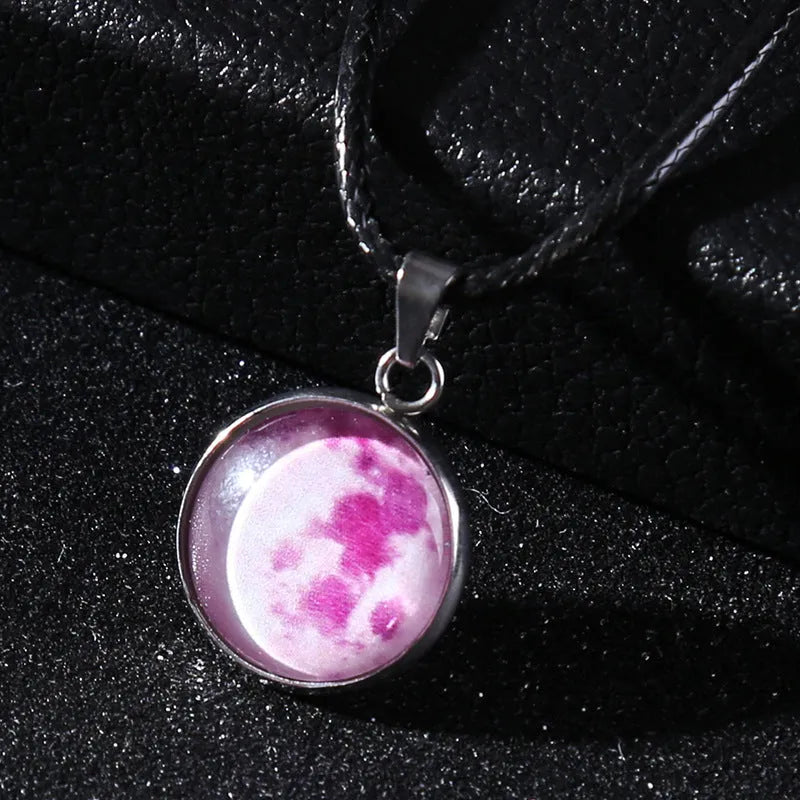 Luminous moon and star constellation pendant necklace with a silver-tone chain on a black background.