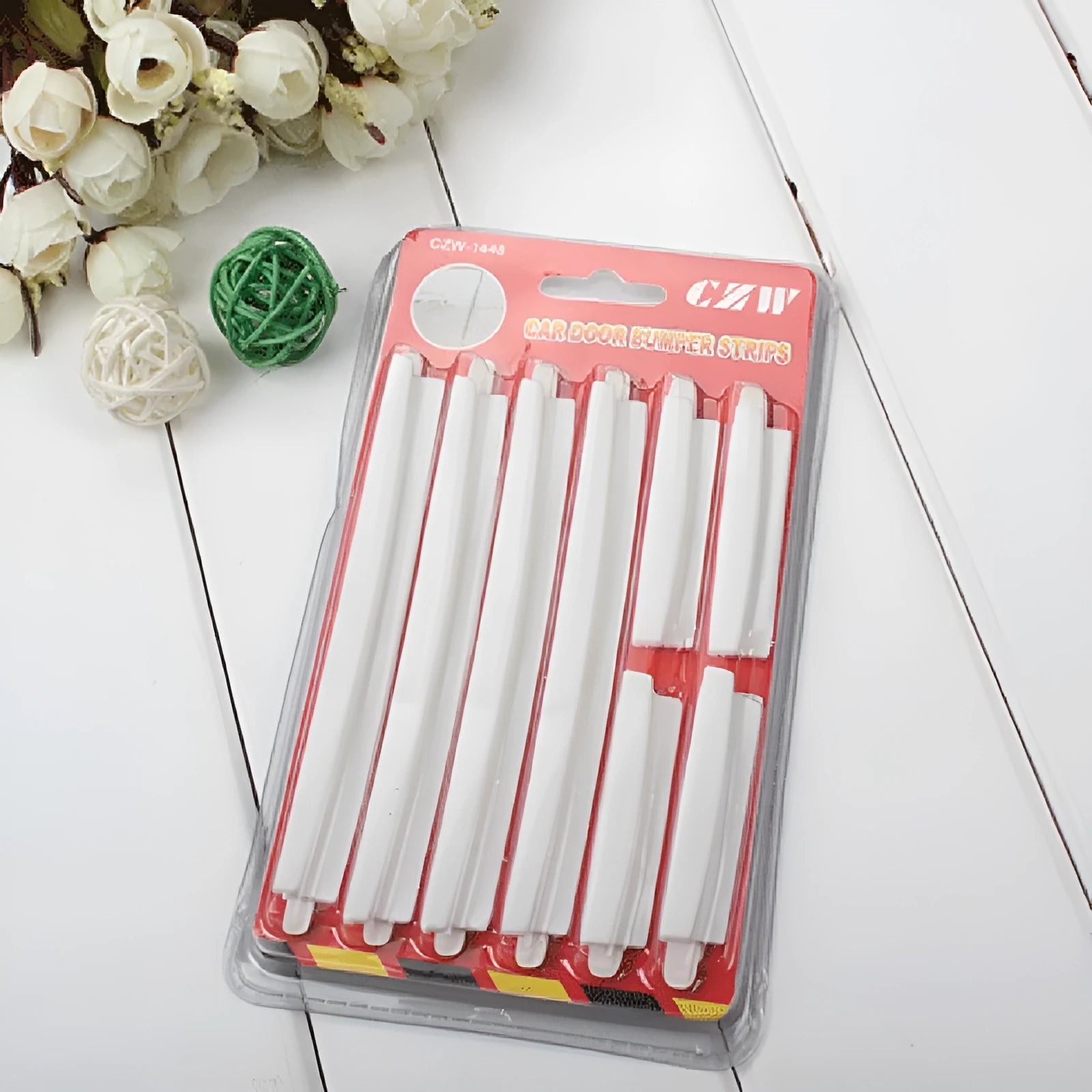 Solid white plastic car door edge protector strip showing its 0.5cm thickness and adhesive backing.