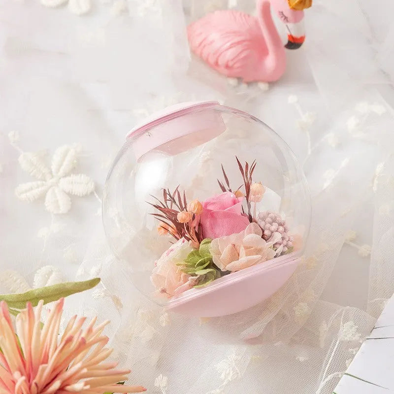 Pink preserved rose ornament with LED lights, shown with and without a decorative base.