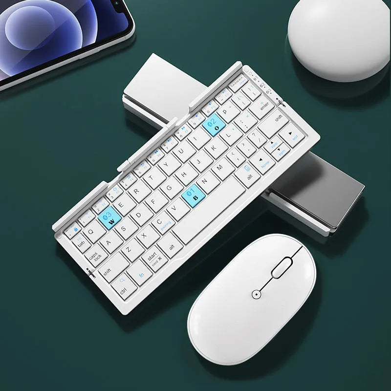 Silver white aluminium folding Bluetooth keyboard shown open next to a smartphone propped on its hidden stand.