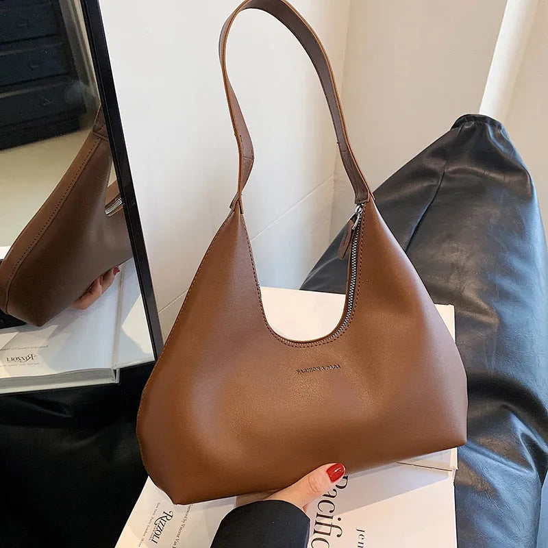 Women's brown retro PU leather shoulder handbag with a pillow shape and single strap.