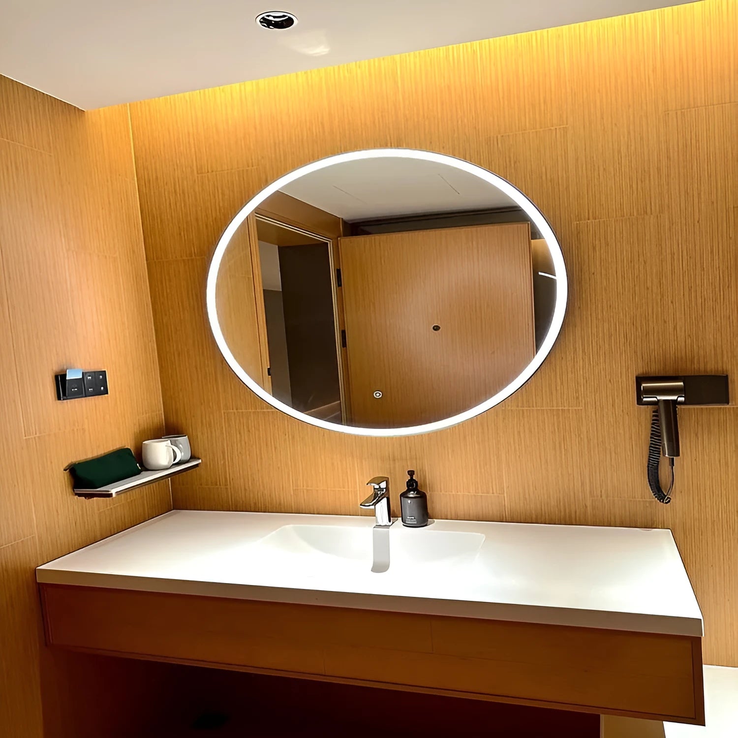 Round black aluminium frame LED bathroom mirror mounted on wall with touch control for light.