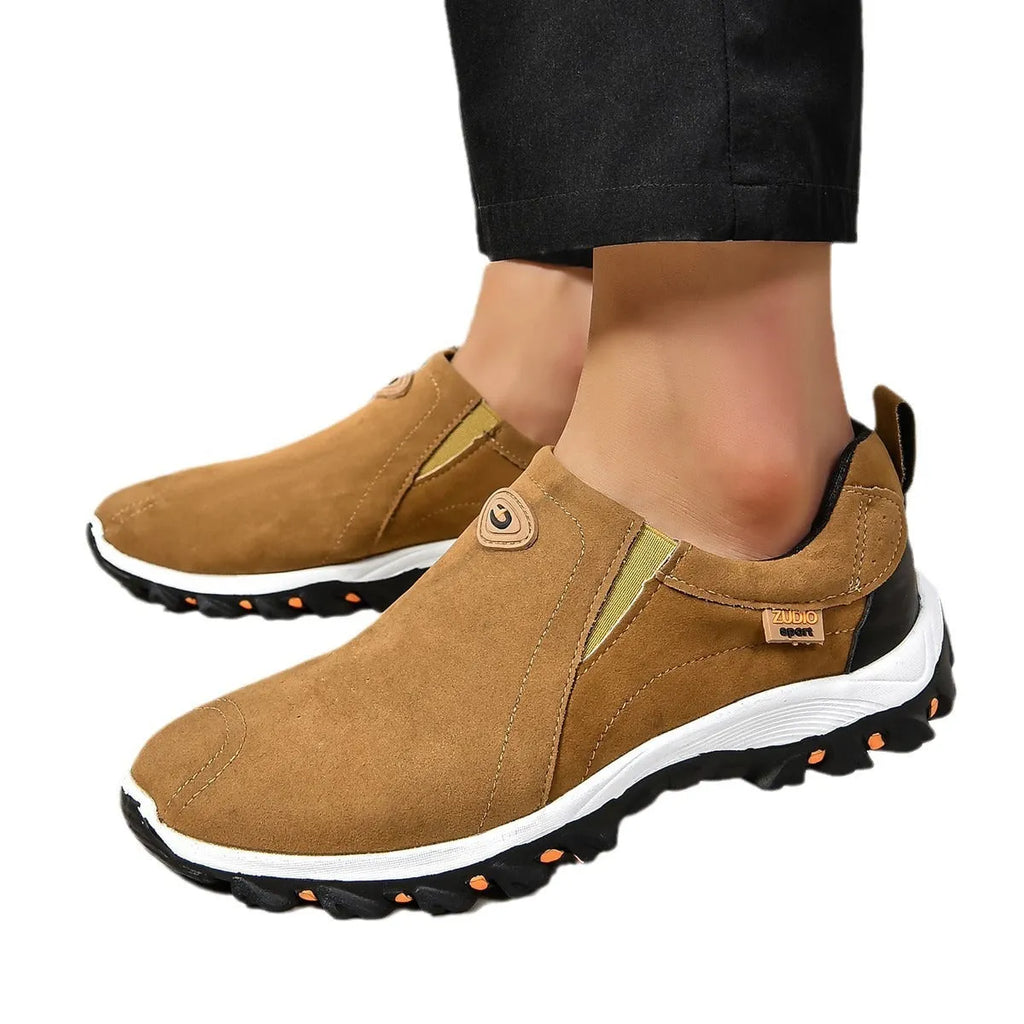 Men's grey slip-on shoe cover with round toe and rubber sole, shown from the side.