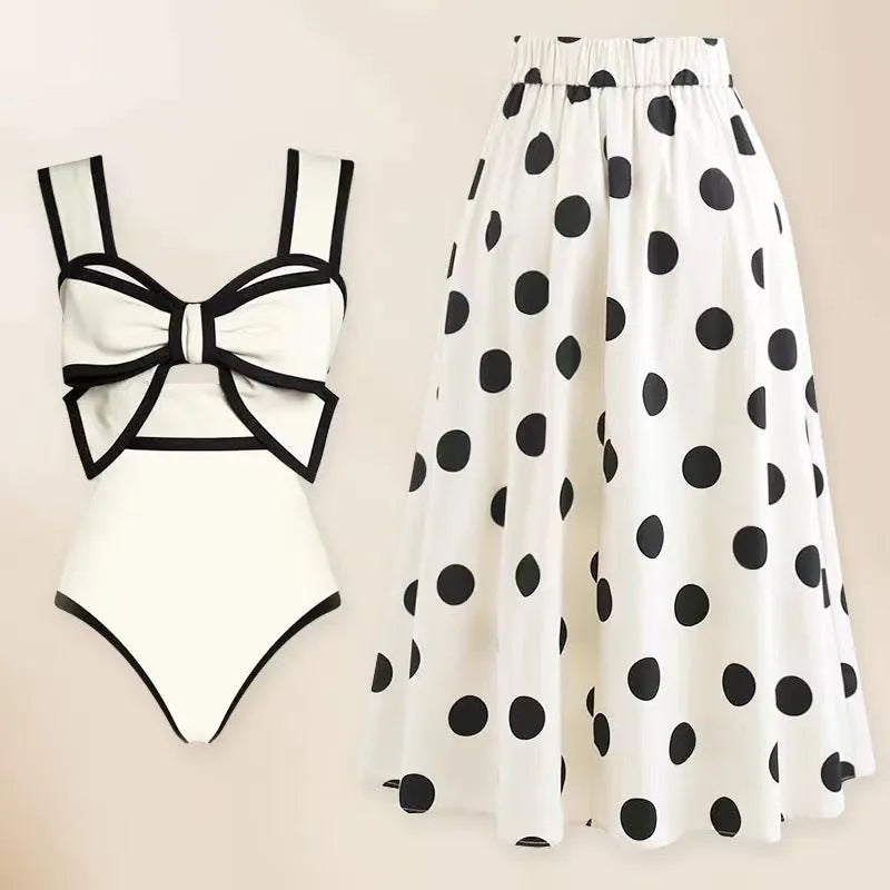 Black one-piece swimsuit for women with a white bow on a short round skirt, showcasing the beach dress style.