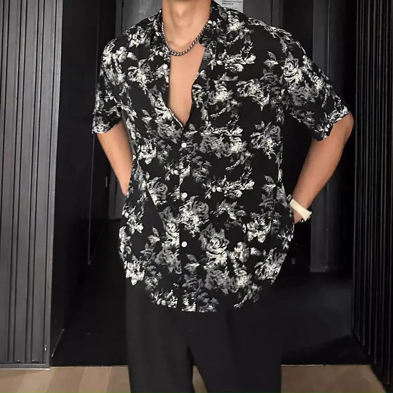Loose-fitting black floral print short sleeve shirt on a hanger.