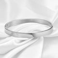 Stainless steel snap bracelet with polished finish in gold colour on a white background