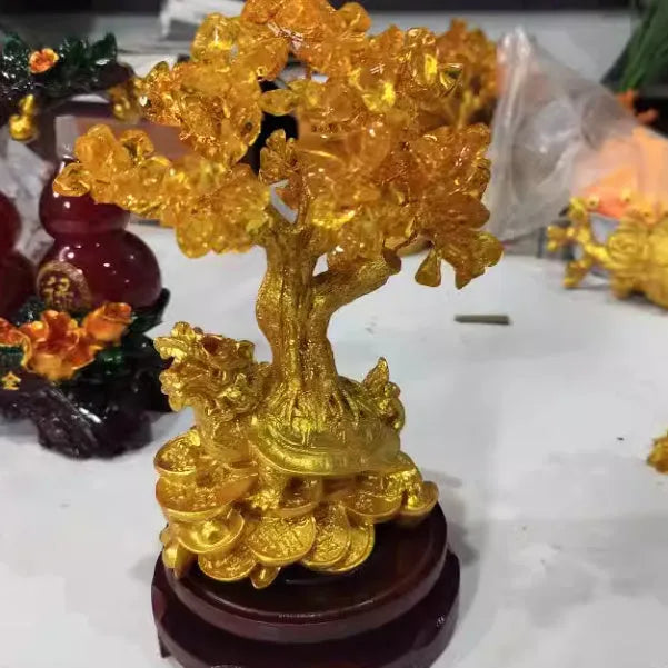 A citrine-coloured resin decorative ornament of a small water turtle and a money tree in Chinese style.